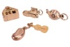 A group of yellow metal charms, to include a 9ct yellow gold articulated house charm, a 9ct gold violin charm, a 9ct gold articulated shoe charm, a 9ct gold handbag charm, the four weighing 6.5 grams; as well as a teapot and a bean charm, both marked 9ct - 2