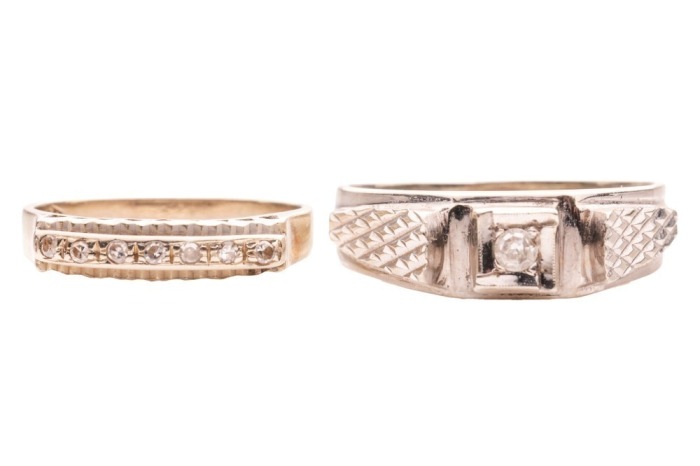 Two diamond-set rings; The first a ring grain-set with seven single-cut diamonds, in white metal (may require re-rhodium plating), with chevron border detail, to a plain tapering ring shank marked &lsquo;750&rsquo;, size L, 2.5 grams; The second a ring grain-set with