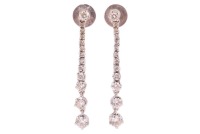 A pair of diamond-set drop earrings, of tapering design, each claw-set with thirteen graduated round brilliant diamonds, in 18ct white gold mounts, with post fittings and earring backs to the reverse; 2.6 grams