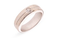 A diamond-set dress ring, flush-set with a round brilliant-cut diamond with an estimated weight of 0.20ct, to a band with a central indentation, Indian assay marks '750', size P, 10.0 grams.