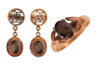 A black star sapphire ring, claw-set in a four-prong setting, flanked by foliate motifs, in a yellow metal mount marked &lsquo;14K&rsquo;, size N, together with a pair of black star sapphire drop earrings, the surmount pierced with the Chinese character for &lsquo;auspicio