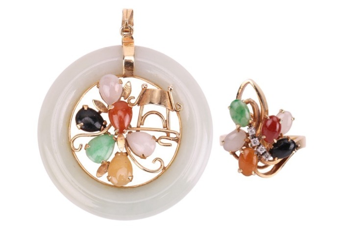 A jadeite pendant and matching cocktail ring, the pendant of circular form comprising a pale greenish-grey jade annulet, with scrolled foliate and a temple centrepiece, set with halequin pear-shaped jade cabochons, on a tapering bail, yellow metal stamped