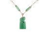A long jadeite link chain, comprising a series of Figaro links, flanked by faceted jadeite bar links with a chamfered edge, suspending a carved jadeite Fuu dog seal with vacant panel, yellow metal surface testing as 14ct, with a gilt suspension loop bail, - 2