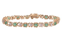 An emerald line bracelet, comprising fourteen round-cut emeralds, interspersed by stylised cross forms and a white-metal illusion panel, every other white metal panel illusion-set with a rose-cut diamond, measuring 18.0cm in length, completed with an inte