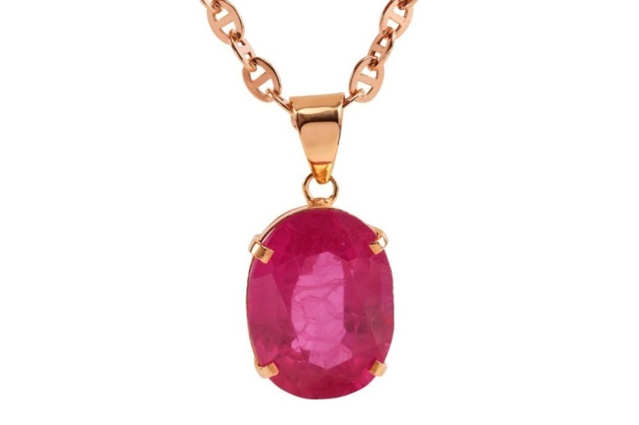 A large synthetic ruby pendant on chain, featuring a large oval-cut synthetic ruby of 18.0 x 13.5 x 8.5 mm, in a claw setting with tapered bail, yellow metal testing as 9ct, on a 60.0 cm long flat anchor link chain with lobster clasp, pink metal stamped '