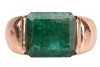 An emerald dress ring, featuring a deep green coloured emerald with sub-translucent transparency, approximately measuring 11.1 x 12.1 mm, bar set on a yellow metal mount surface tested as 18ct, with trumpeted shoulders to a court profile shank, unmarked, - 2