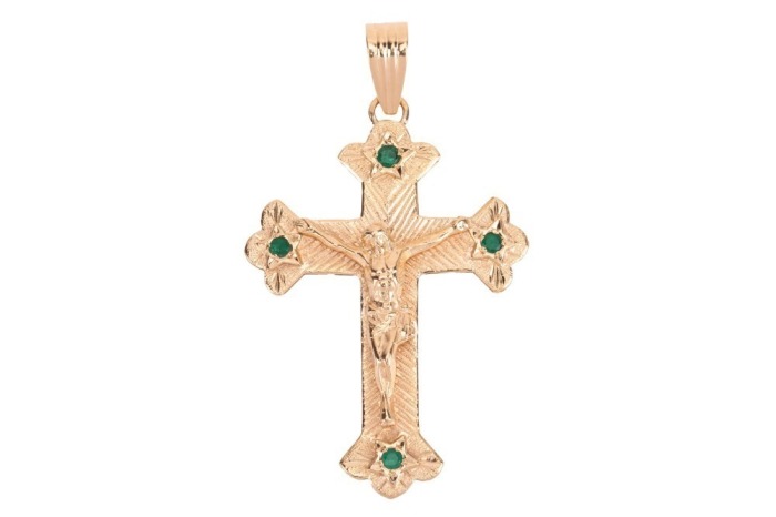 A gem-set crucifix pendant in 18ct yellow gold, the arms decorated with star-set circular-cut emeralds, on a reeded bail, British assay marks, 7.0cm drop, 14.8 grams.