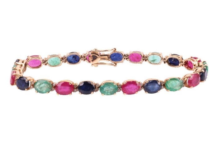 A multi-gem set bracelet, composed of oval mixed-cut glass-filled rubies, dyed sapphires and emeralds, claw-set in an alternating pattern, in a yellow metal mount with integrated push bar clasp and safety catch, marked &rsquo;18K&rsquo;, measuring approximately 19.5c