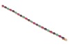 A multi-gem set bracelet, composed of oval mixed-cut glass-filled rubies, dyed sapphires and emeralds, claw-set in an alternating pattern, in a yellow metal mount with integrated push bar clasp and safety catch, marked &rsquo;18K&rsquo;, measuring approximately 19.5c - 3