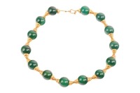 An agate bead necklace, comprising fourteen spherical dyed agate beads of 16.5mm, capped with graduated cups, completed with a hook clasp with twisted cable details, unmarked yellow metal surface testing as 18ct, overall length 43.0 cm, 99.6 grams. Please