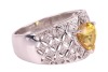A yellow sapphire and diamond-set dress ring, claw-set with a heart-shaped yellow sapphire, to a diamond-set openwork ring, of lattice design, in white metal marked &lsquo;18K&rsquo; and &lsquo;750&rsquo;, size M; 5.8 grams - 3