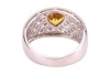 A yellow sapphire and diamond-set dress ring, claw-set with a heart-shaped yellow sapphire, to a diamond-set openwork ring, of lattice design, in white metal marked &lsquo;18K&rsquo; and &lsquo;750&rsquo;, size M; 5.8 grams - 4