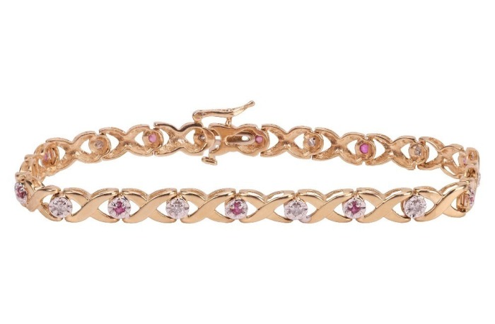 A gem-set floral bracelet, the crossover links with flower motifs, set with round brilliant diamonds and round pink sapphires, in an alternating pattern, to a bi-colour metal mount, with integrated push bar clasp and safety catch, marked &lsquo;14K&rsquo;; 8.0 grams