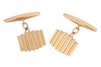 A pair of ridged cufflinks, the panels with vertical grooves, chain connected to torpedo fittings, yellow metal marked '18ct', 9.10 grams.