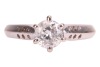 A diamond solitaire ring, comprising a central round brilliant-cut diamond in a six claw setting, with an estimated carat weight of 0.83ct, to tapering shoulders with circular drilled detail, to an 18ct white gold knife-edge band, size N, 4.9 grams. - 2
