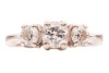 A diamond trilogy ring, with an estimated total diamond weight of 1.00ct, comprising three graduated round brilliant-cut diamonds in claw setting, between tapered shoulders leading to a flat shank, white metal stamped '750', size J, 4.3 grams. Approximate - 2