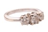 A diamond trilogy ring, with an estimated total diamond weight of 1.00ct, comprising three graduated round brilliant-cut diamonds in claw setting, between tapered shoulders leading to a flat shank, white metal stamped '750', size J, 4.3 grams. Approximate - 3
