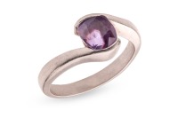 A purple sapphire crossover ring, featuring a cushion-cut purple sapphire of 7.1mm x 6.1mm x 4.5mm, set between bypass shoulders leading to a tapering shank, unmarked white metal testing as platinum, size N&frac12;, 6.4 grams. Accompanied by a Stalwart gem repor