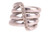 A diamond-set coil ring, by Maria Grazia Cassetti, centrally embellished with an applied zig-zag motif encrusted with diamond accents, white metal signed and bearing Italian assay marks '750' and registration marks, 1.5 cm wide, size Q, 19.7 grams. - 2