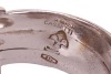 A diamond-set coil ring, by Maria Grazia Cassetti, centrally embellished with an applied zig-zag motif encrusted with diamond accents, white metal signed and bearing Italian assay marks '750' and registration marks, 1.5 cm wide, size Q, 19.7 grams. - 5