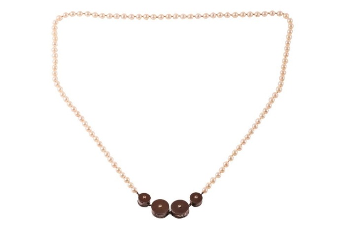A long cultured pearl necklace with a Modernist centrepiece, comprising four cylinders each set with a diamond accent on both sides, attached to a hand-knotted strand of round cultured pearls, measuring 6.2 mm in diameter, metal testing as silver and 18ct