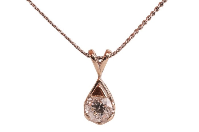 A diamond-set solitaire pendant, claw-set with a round brilliant diamond measuring approximately 4.25mm with an estimated carat weight of 0.28ct, in a teardrop-shaped pendant, to a white metal chain with bolt ring clasp, marked &lsquo;14K&rsquo;, measuring approximat