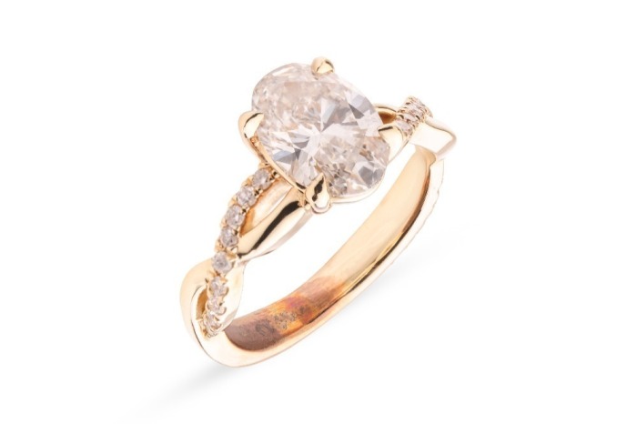 A laboratory-grown diamond solitaire ring, centred with an oval-cut diamond of 1.51ct, between twisted diamond-set shoulders leading to shank, in unmarked yellow metal surface testing as 14ct, size K, 4.3 grams. Diamond has been inscribed with an IGI repo