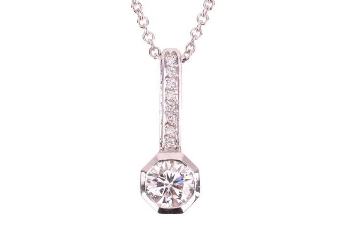A diamond-set pendant, composed of a round brilliant diamond measuring approximately 5.4mm, with an estimated carat weight of 0.60ct, bezel-set in a hexagon-shaped setting, with a diamond-set surmount, in white metal surface tested as 18ct, to a white met