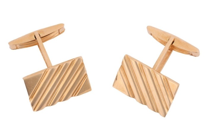 A pair of cufflinks of rectangular form with striated design, the panels fitted with toggle swivels, yellow metal marked '750', panel measures 2.0 x 1.3 cm, total weight of items 16.73 grams.