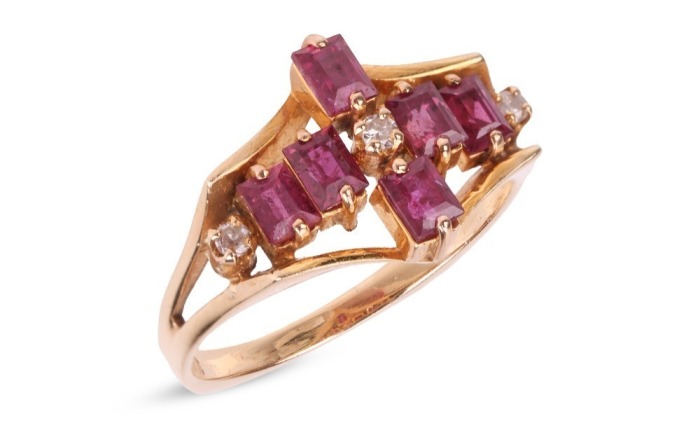 A ruby and diamond dress ring, six rectangular table-cut rubies and three single-cut diamonds composing a cruciform, between bifurcated shoulders leading to an angular shank, yellow metal stamped '585', size L, 2.8 grams.