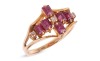 A ruby and diamond dress ring, six rectangular table-cut rubies and three single-cut diamonds composing a cruciform, between bifurcated shoulders leading to an angular shank, yellow metal stamped '585', size L, 2.8 grams.