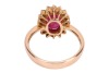 A ruby and diamond-set cluster ring, centred with an oval mixed-cut ruby measuring approximately 10.2mm x 7.2mm, surrounded by sixteen round brilliant diamonds, claw-set in a yellow metal mount marked &lsquo;750&rsquo;, size S; 5.9 grams - 3