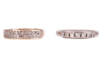 Two rings; comprising a diamond-set seven-stone ring, in a white metal mount marked &lsquo;750&rsquo;, size N, together with a diamond-set dress ring, grain-set with round brilliant diamonds in a 9ct yellow gold mount, size L; 4.8 grams (2)