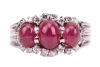 A ruby cabochon and diamond dress ring, comprising three graduated oval ruby cabochons, embellished with single-cut diamonds, to a shank composed of four knife-edged bands, in white metal stamped '750', size R&frac12;, 7.5 grams. - 2