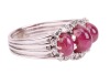 A ruby cabochon and diamond dress ring, comprising three graduated oval ruby cabochons, embellished with single-cut diamonds, to a shank composed of four knife-edged bands, in white metal stamped '750', size R&frac12;, 7.5 grams. - 3
