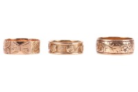 Three band rings; The first a 9ct yellow gold band ring, with floral engraving, size R, the band 8.2mm wide, 5.19 grams; The second a diamond-set band ring, featuring rose and scrolled details, the rose motifs interspersed with a round brilliant-cut diamo