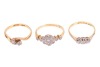 Three rings; comprising a diamond-set floral cluster ring, in a bi-colour metal mount marked &lsquo;18ct&rsquo;, size O1/2, a diamond-set three-stone ring, in a bi-colour metal mount marked &lsquo;18ct&rsquo;, size N, and a diamond-set crossover ring in a yellow metal mount mark - 3