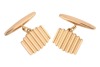A pair of ridged cufflinks, the panels with vertical grooves, chain connected to torpedo bar fittings, yellow metal marked '18ct', 9.95 grams.