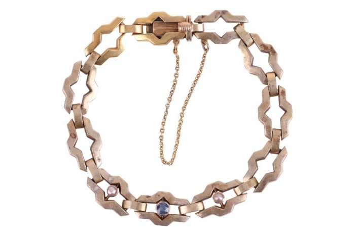 A fancy link bracelet set with pearl and sapphire, comprising a series of hinged geometric links, centred with a circular-cut sapphire in a millgrained collet, flanked by two split pearls, completed with a conforming box clasp, metal stamped '585', overal
