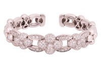 David Morris - a diamond-set flexible torque bangle, of quatrefoil design, comprising a series of graduated floral links, central segment encrusted with round brilliant-cut diamonds, with an estimated total weight of 1.65ct, white metal signed and stamped