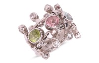 Dior - a 'Deux Epices' multi-gem dress ring, composed of two bands flanking an oval-cut tourmaline, peridot and aquamarine in collets, with diamond accents and further decorated with articulated teardrop fringe to the border, signed and numbered, white me