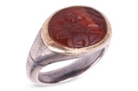 A Roman carnelian intaglio ring, the oval carnelian panel carved with a female deity, possibly Justice, holding scales, with a whip in the other hand, collet-set to a later shank, unmarked bi-coloured metal surface testing as 18ct and silver, ring head 1.