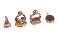 A pink metal swivel seal cum locket, set to either side with a carnelian and a bloodstone; together with two 19th century seals, one with a carnelian intaglio of a classical male bust figure, a further with an intaglio monogram and a 19th century gilt met