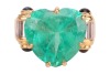 A large heart-shaped emerald dress ring, the emerald measures 13.8 x 15.0 x 8.2 mm, claw-set to the centre between trumpeted shoulders of scroll form, embellished with baguette-cut diamonds and sapphire cabochon terminals, leading to a tapering flat shank - 2