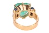 A large heart-shaped emerald dress ring, the emerald measures 13.8 x 15.0 x 8.2 mm, claw-set to the centre between trumpeted shoulders of scroll form, embellished with baguette-cut diamonds and sapphire cabochon terminals, leading to a tapering flat shank - 4
