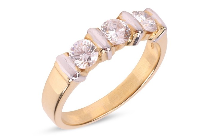 A diamond three-stone dress ring, with an estimated total diamond weight of 0.87ct, comprising three round brilliant-cut diamonds of 4.3mm, in a two-toned bar setting, leading to a tapering flat shank, Italian assay marks '750', size Q, 5.6 grams.