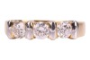 A diamond three-stone dress ring, with an estimated total diamond weight of 0.87ct, comprising three round brilliant-cut diamonds of 4.3mm, in a two-toned bar setting, leading to a tapering flat shank, Italian assay marks '750', size Q, 5.6 grams. - 2