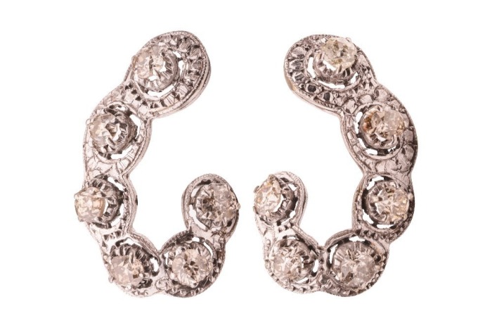 A pair of earrings set with old-cut diamonds, the scalloped hook-shaped mount, each illusion-set with six old-cut diamonds, with an estimated total weight of 2.16ct for the pair, fitted with post and a hinged back, unmarked white metal testing as 9ct, 2.8