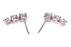 A pair of diamond-set stud earrings, each consisting of three graduated round brilliant-cut diamonds, with an estimated total weight of 1.00ct for the pair, ear post fittings, butterfly backs deficient, unmarked white metal surface testing as 18ct, 1.3 cm - 2
