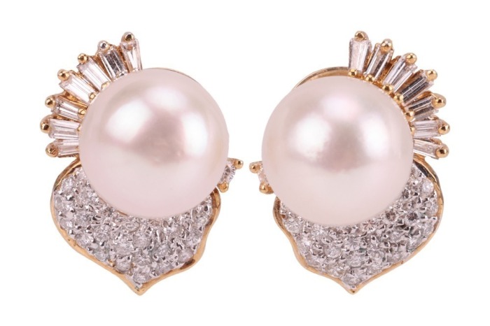 A pair of cultured pearl and diamond-set earrings, the cultured pearls measuring approximately 9.5mm, each flanked by a stylised leaf design panel, pav&eacute;-set with diamonds, accented by tapered baguette-cut diamonds, in a yellow metal mount with post fittin